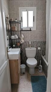 a bathroom with a toilet and a sink and a window at Sweetcasitaarinagaplaya in Arinaga