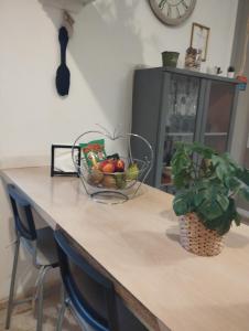 a counter with a bowl of fruit and a plant on it at Sweetcasitaarinagaplaya in Arinaga +24 photos