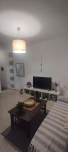 a living room with a television and a coffee table at Sweetcasitaarinagaplaya in Arinaga