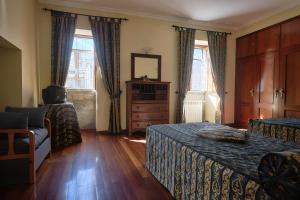 a bedroom with two beds and a dresser and two windows at Casa do Mogadouro in Mesquitela +73 photos