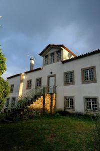 a large white house with a staircase in front of it at Casa do Mogadouro in Mesquitela