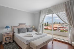 a bedroom with a bed and a large window at Marina Vilamoura Penthouse Luxury in Vilamoura +26 photos