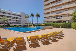 a row of lounge chairs and a swimming pool at Marina Vilamoura Penthouse Luxury in Vilamoura