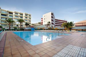 a large swimming pool with palm trees and buildings at Apartamento Yumbo Roque Nublo in San Bartolomé