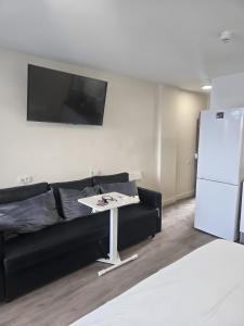a living room with a black couch and a white table at Apartamento Yumbo Roque Nublo in San Bartolomé