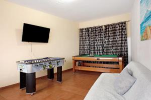 a living room with a pool table and a tv at El Faro Sardina in Sardina