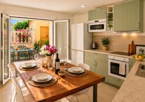 a kitchen with a wooden table with white chairs at El Jardin Secreto in Oria +13 photos