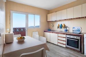 a kitchen with a table and a dining room at El Faro Sardina in Sardina