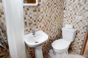 a bathroom with a toilet and a sink at El Faro Sardina in Sardina +16 photos
