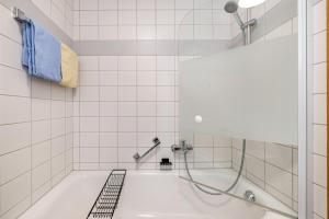 a bathroom with a tub with a shower at Fewo Brünnstein - Nr 27 Pool, Sauna in Oberaudorf +16 photos