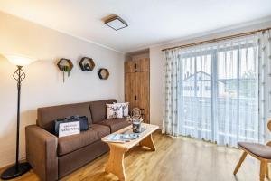a living room with a couch and a table at Fewo Brünnstein - Nr 27 Pool, Sauna in Oberaudorf