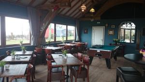 een restaurant met tafels en stoelen en een pooltafel bij Chalet Camping Natuurlijk Limburg in Remersdaal