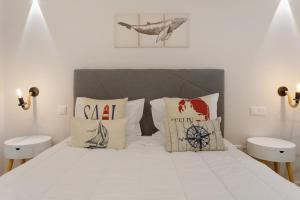 a bedroom with a white bed with pillows at O Marinheiro 15A in Caniçal +30 photos