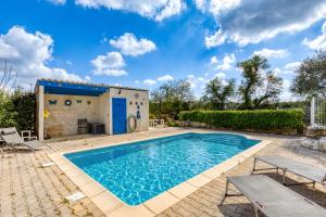 a swimming pool in front of a house with a building at Charmante location vacances in Montagnac