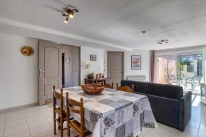 a dining room with a table and a couch at Charmante location vacances in Montagnac