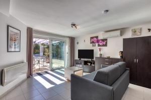 a living room with a couch and a television at Charmante location vacances in Montagnac