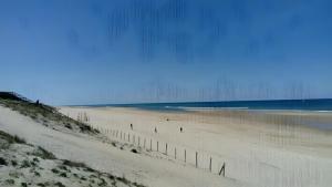a beach with people walking on the sand and the ocean at T3 Mimizan Plage in Mimizan-Plage +2 photos