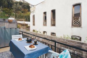 a blue table with two plates of food on a balcony at P&P Apartment in Forio d'Ischia
