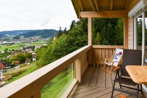 a balcony of a house with a table and chairs at Panoramahisli 4 in Fischerbach +4 photos
