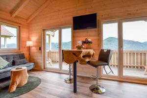 a living room with a table and a couch and windows at Panoramahisli 4 in Fischerbach