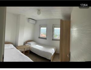 a small bedroom with two beds and two windows at Villa Ilijas 3 bedrooms in Ilijaš