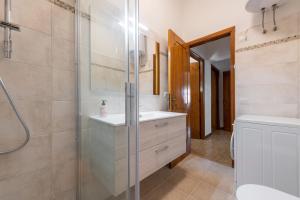 a bathroom with a glass shower and a sink at Casa Vacanze Teulada in Teulada +15 photos