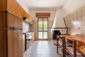 a kitchen with a refrigerator and a table in it at Casa Vacanze Teulada in Teulada