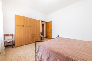 a bedroom with a large bed and wooden cabinets at Casa Vacanze Teulada in Teulada