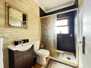 a bathroom with a toilet and a sink and a shower at Refugio Senhora Paz in Marinhas +38 photos