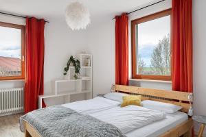 a bedroom with a bed with red drapes at Landhaus Trautwein in Vogtsburg