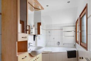 a white bathroom with a sink and a tub at Landhaus Trautwein in Vogtsburg +207 photos