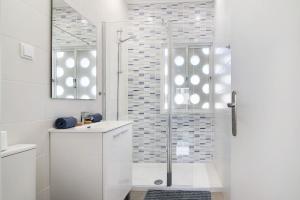 a white bathroom with a shower with a glass door at Skipper House in Loulé +19 photos