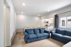 a living room with blue couches and a table at Skipper House in Loulé