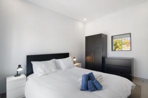 a bedroom with a white bed with two blue towels on it at Skipper House in Loulé
