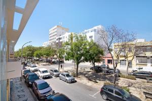 a city street with cars parked in a parking lot at Skipper House in Loulé