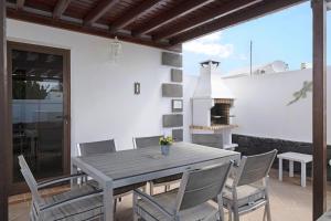 a table and chairs on a patio with a fireplace at Casa Elian in Lanzarote
