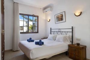 a bedroom with a bed with two blue pillows on it at Casa Elian in Lanzarote +18 photos