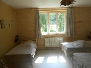 a bedroom with two beds and a window at Gîte Les Chamois 15 Personnes in Les Rousses