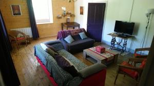 a living room with a couch and a tv at Gîte Les Chamois 15 Personnes in Les Rousses
