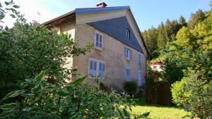 an old stone house with a gambrel roof at Gîte Les Chamois 15 Personnes in Les Rousses