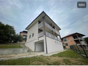 a white house with a garage and a building at Villa Ilijas 3 bedrooms in Ilijaš