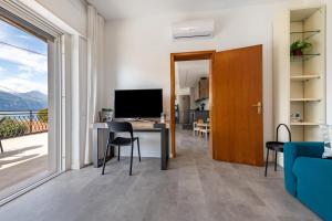 ein Wohnzimmer mit einem Schreibtisch mit Computer und einem Fenster in der Unterkunft Cà Granda Brenzone in Brenzone sul Garda