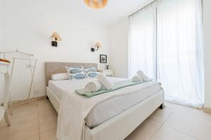 a white bedroom with a bed and a large window at Apartamento Sf1 in L'Ametlla de Mar