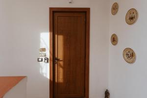 a wooden door in a room with plates on the wall at P&P Apartment in Forio d'Ischia