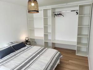 a bedroom with a bed and white shelving at Gîte Les Pirouettes in Pirou