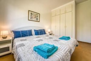 a bedroom with a bed with blue towels on it at Villa Orchidée - Coves Noves in Punta Grossa +21 photos