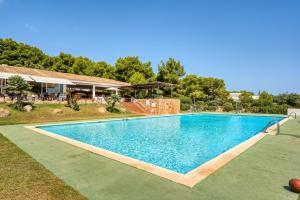 a large blue swimming pool in a yard at Villa Orchidée - Coves Noves in Punta Grossa