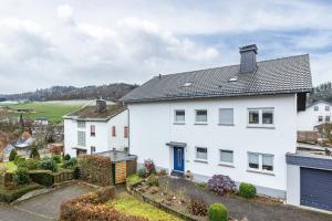 a white house with a blue door at Ferienwohnung Brune in Schmallenberg