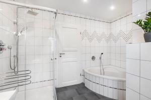 a white bathroom with a tub and a shower at Ferienwohnung Brune in Schmallenberg +18 photos