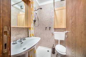 a bathroom with a white sink and a toilet at Apt Vista sulla Vallata in Mazzin +12 photos